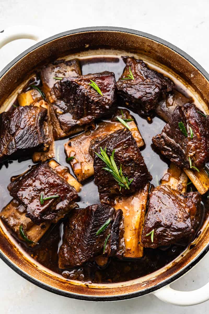 An overhead birds-eye view of beef short ribs in a braising pan.