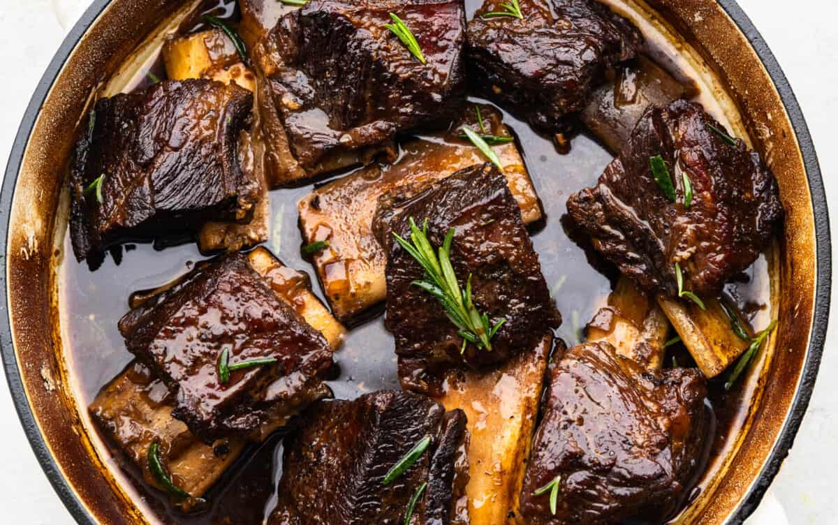 An overhead view of beef short ribs in a braising pan.