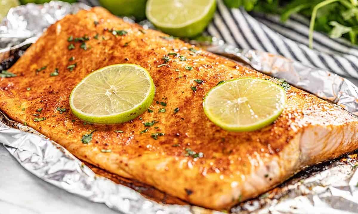 a filet of salmon with chili and lime in foil.